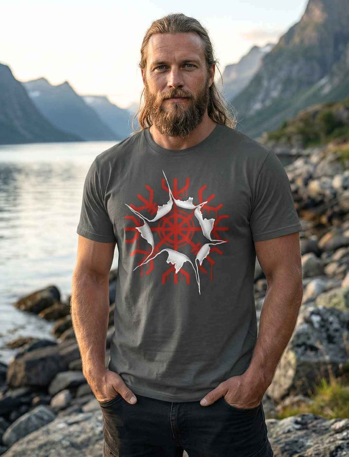 Mann im anthrazitfarbenen aegishjalmur Awakening Shirt mit rotem Schutzzeichen vor Berg- und Fjordkulisse