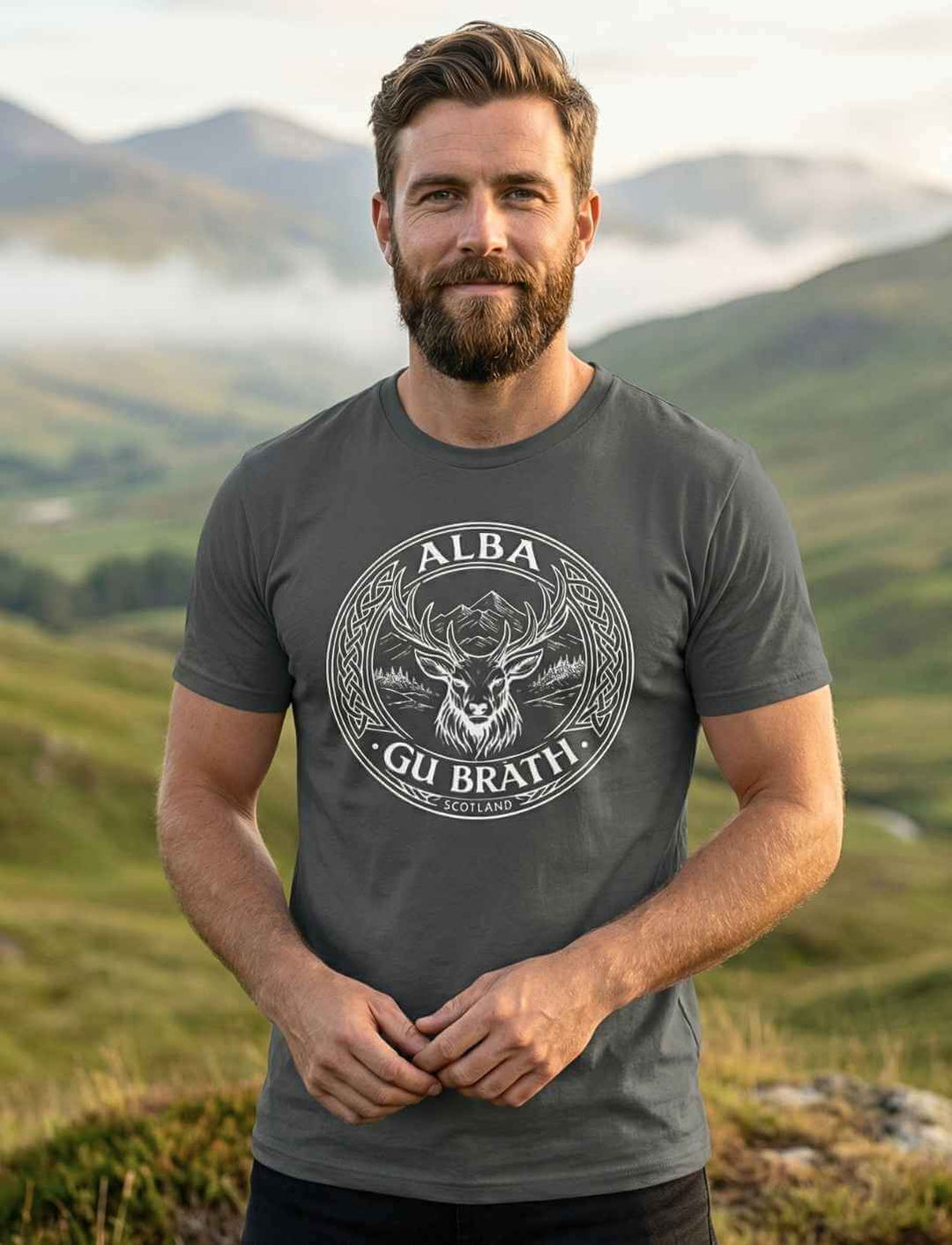 Mann trägt Alba gu bràth Unisex T-Shirt Anthrazit mit schottischem Hirsch Emblem im Freien