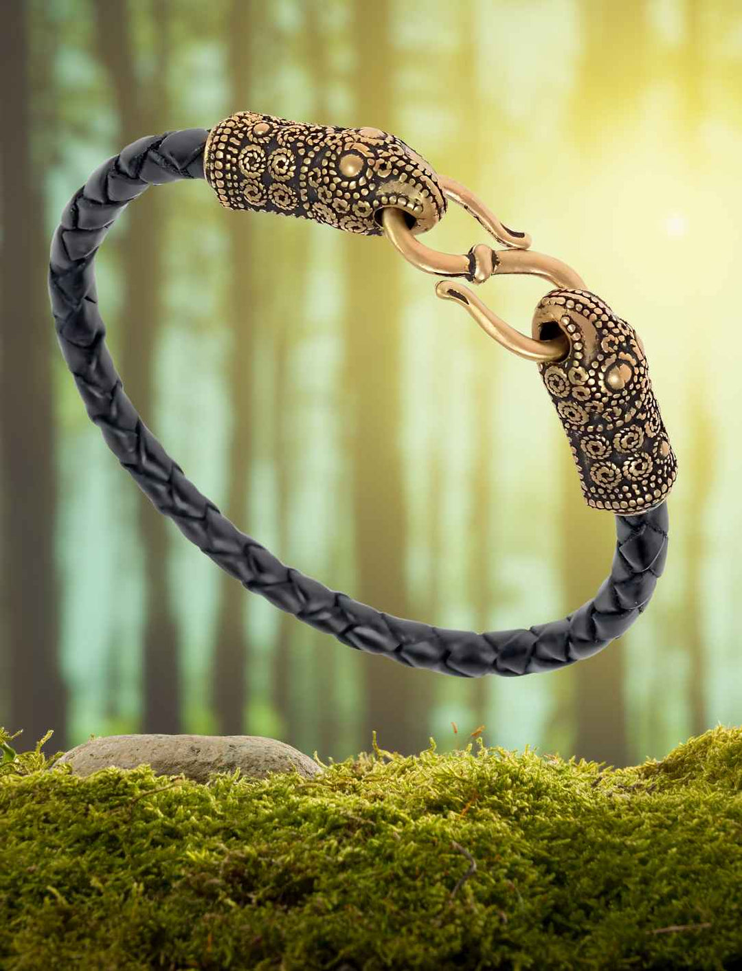 Schwarzes Lederarmband des Rabenwächters mit  Rabenköpfen aus Bronze auf Wald/Moos Hintergrund.