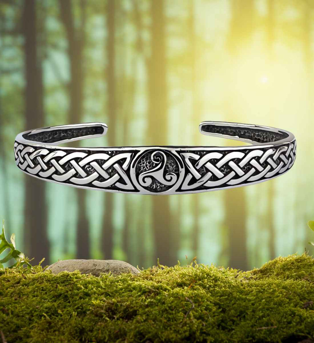 Armreif des Ewigen Knotens, präsentiert in einer natürlichen Waldszene, betont die Verbindung zur keltischen Natur und Tradition.