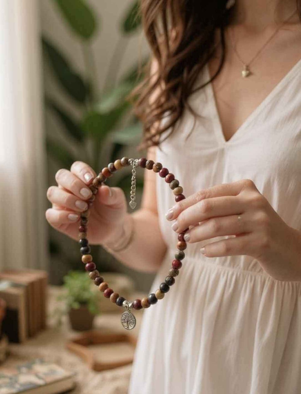 Frau in weißem Kleid hält Runental-Choker „Atem des Waldes“ mit Lebensbaum-Anhänger aus Silber in den Händen