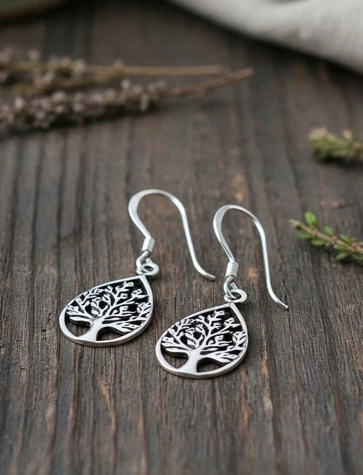 Lebensbaum Ohrringe aus 925 Sterling Silber in Blattform auf Holz und grünen Zweigen