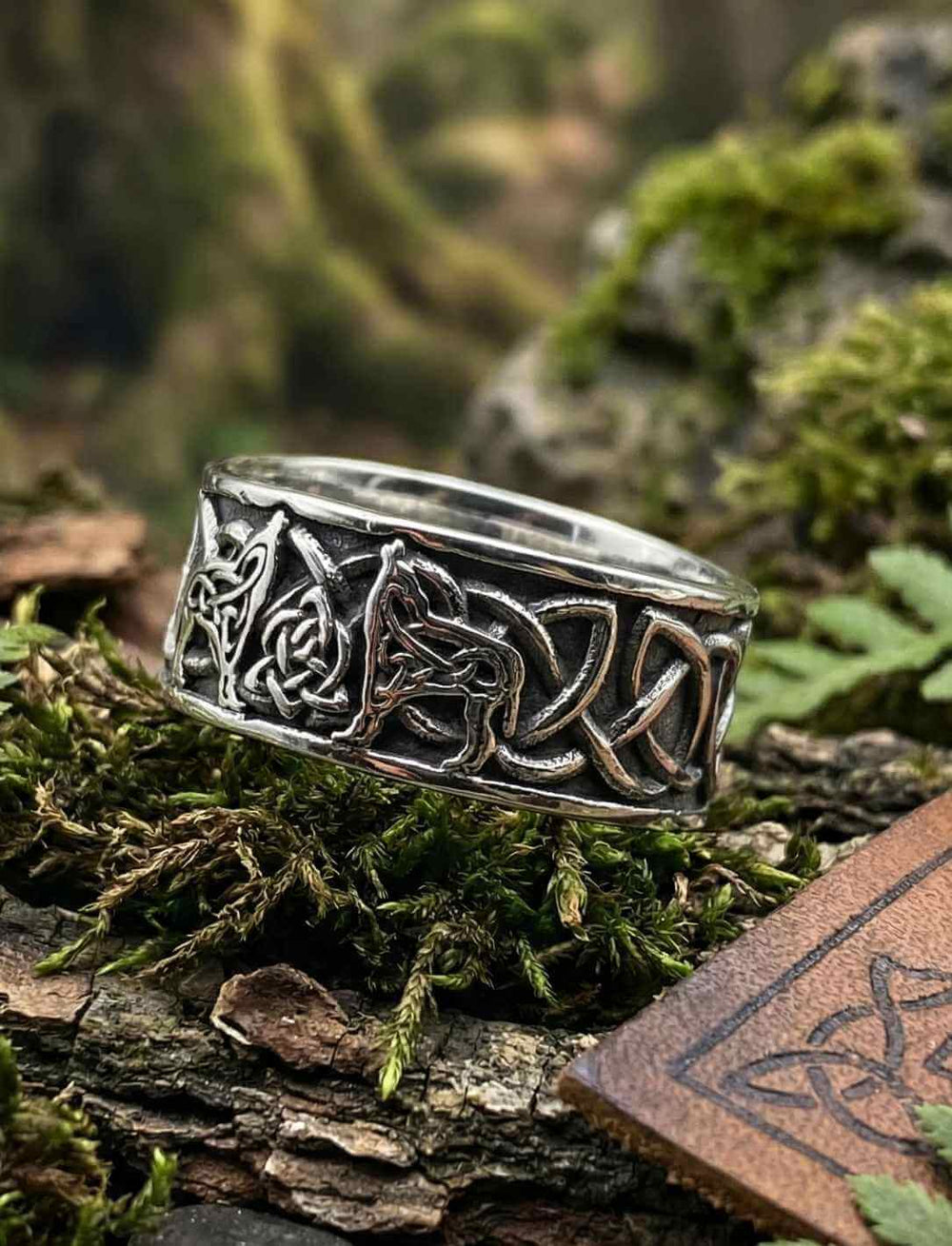 Detailansicht des keltischen Wolfsrings Edelstahl mit ineinanderlaufenden Knoten und Wolfsmotiven, fotografiert im Waldambiente