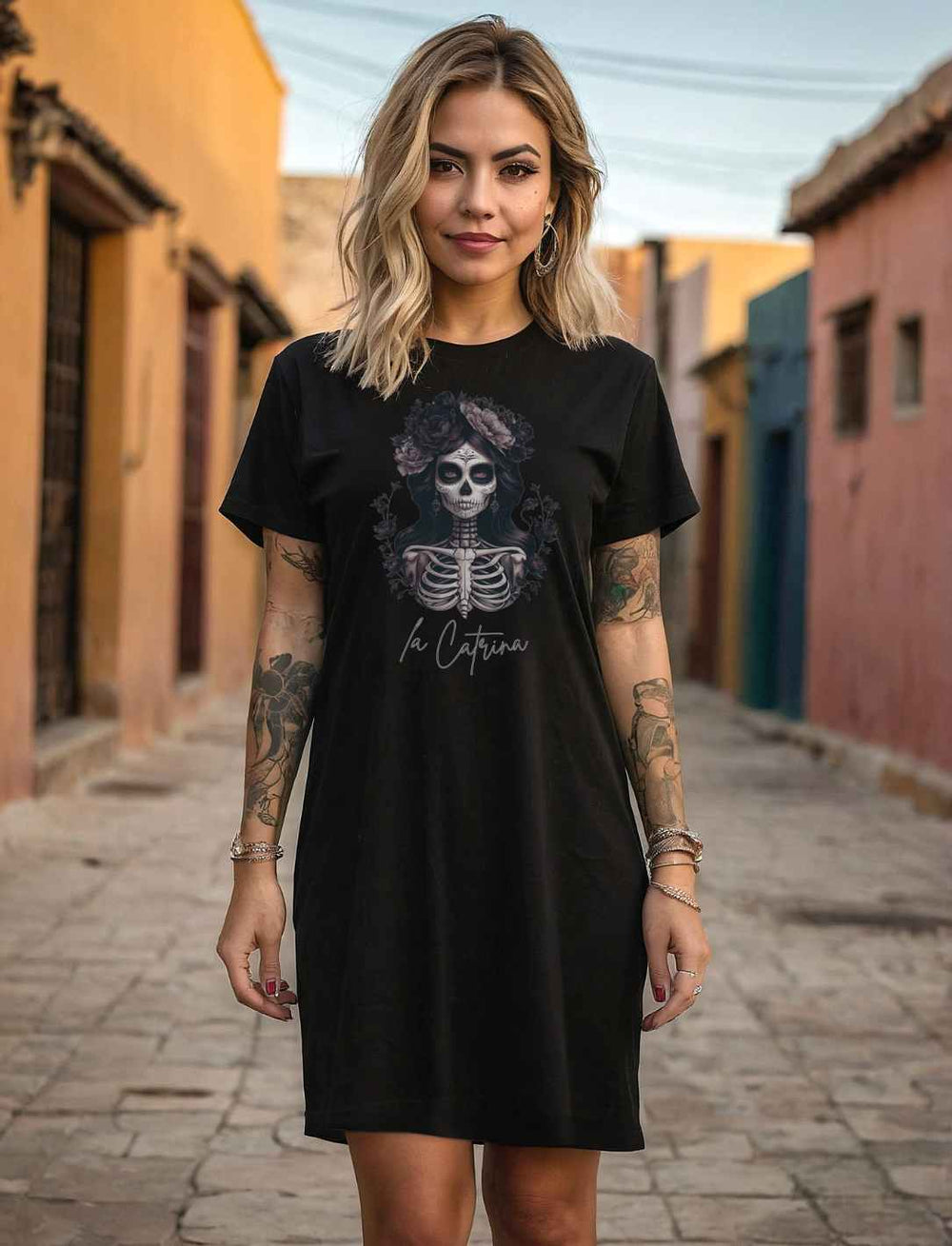 Junge Frau trägt das Catrina Deluxe T-Shirt Kleid in Schwarz – Elegantes Kleid aus 100% Bio-Baumwolle mit Catrina-Motiv, inspiriert vom Día de los Muertos.