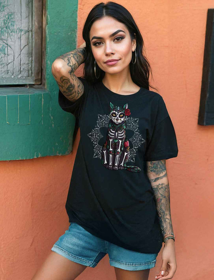 Frau trägt das Catrina Felina Unisex Oversized Shirt in Schwarz – ein lockeres, stilvolles Shirt mit mystischem Katzen-Design, inspiriert vom Día de los Muertos, perfekt für einen lässigen und ausdrucksstarken Look.