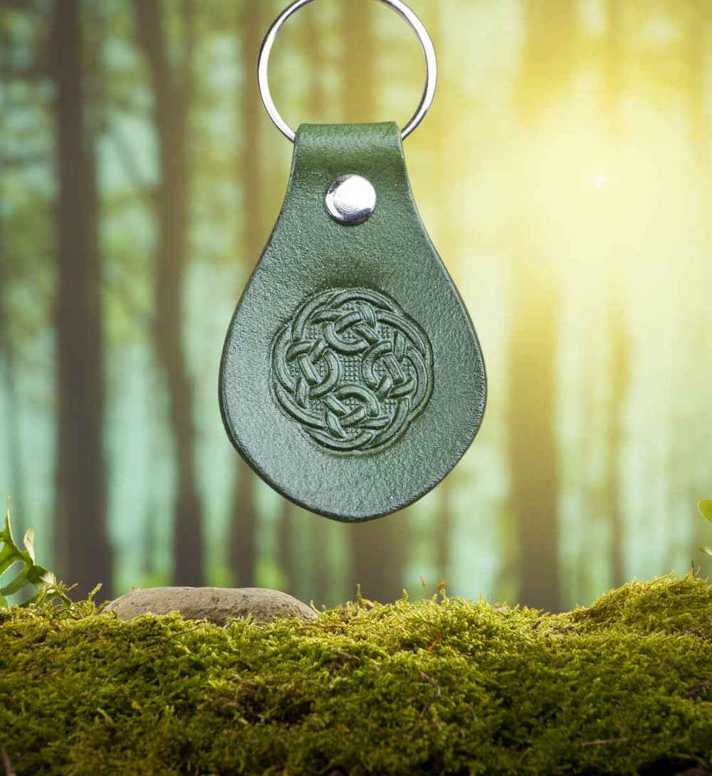 Celtic Infinity' Leder-Schlüsselanhänger, kunstvoll präsentiert auf einem moosigen Waldboden – verbinde dich mit der Natur und keltischer Kultur, verfügbar bei Runental.de.