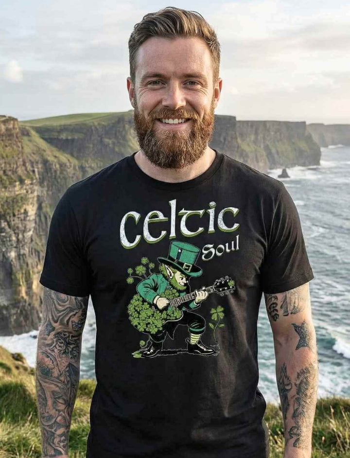 Junger Mann trägt das Celtic Soul T-Shirt in Schwarz an der malerischen Küste Irlands, umgeben von rauer Natur und dem weiten Meer.