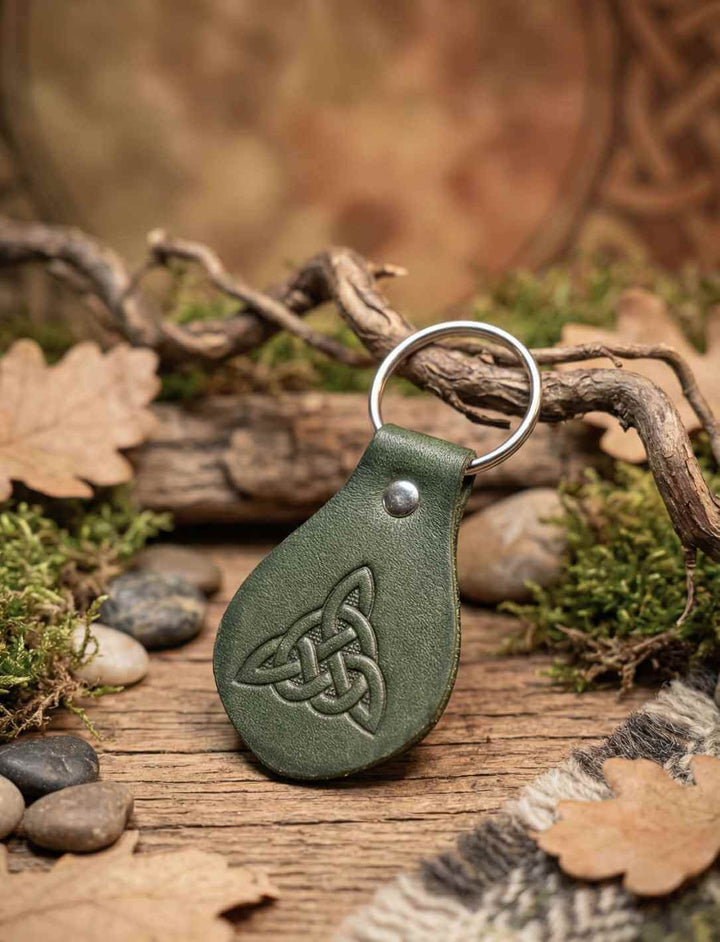Grüner Leder Schlüsselanhänger mit keltischem Trinity Knot, auf Holz und Moos arrangiert