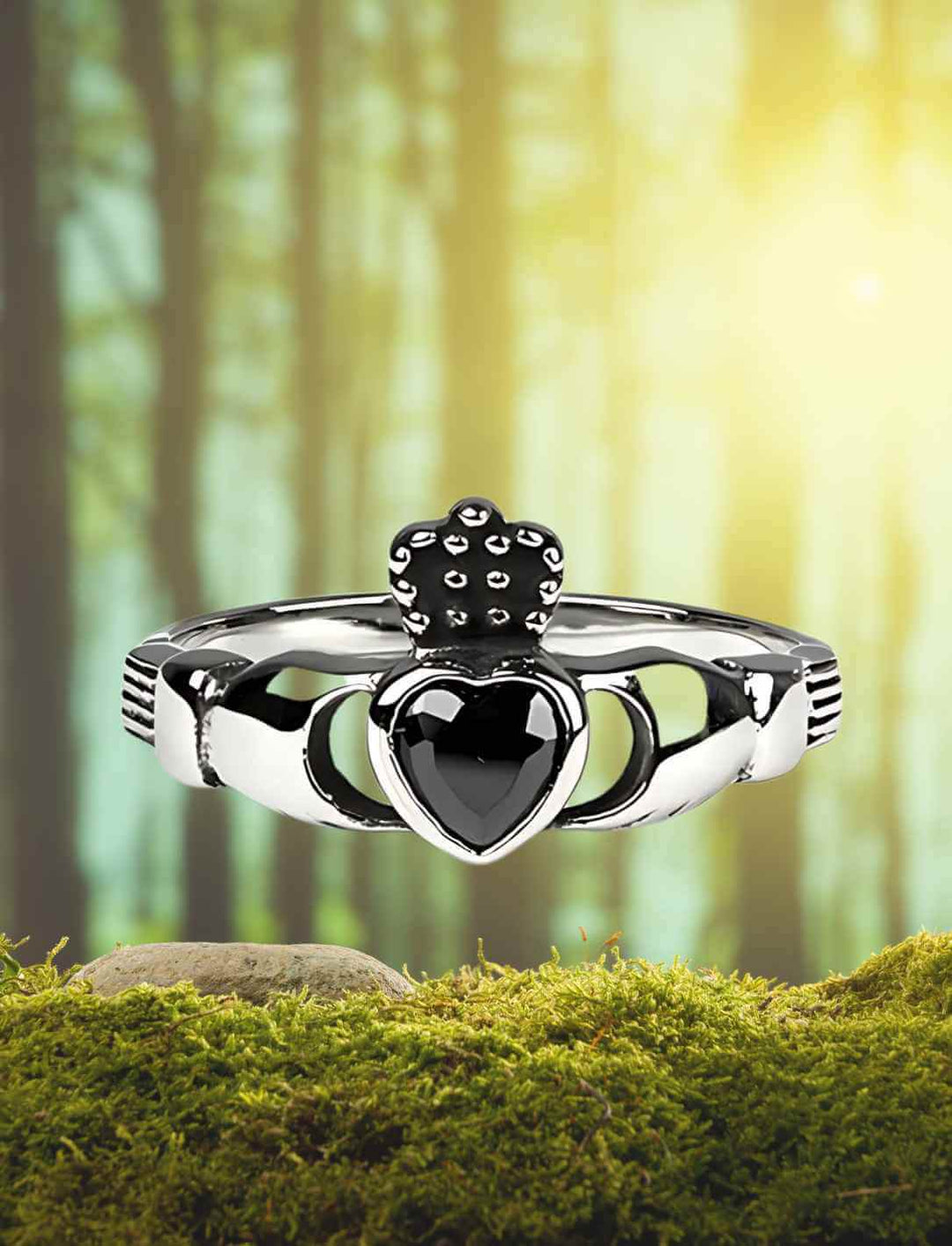 Claddagh Ring – Schwarzes Herz der Treue aus Edelstahl, inszeniert auf einer moosbewachsenen Lichtung mit mystischer Waldkulisse.