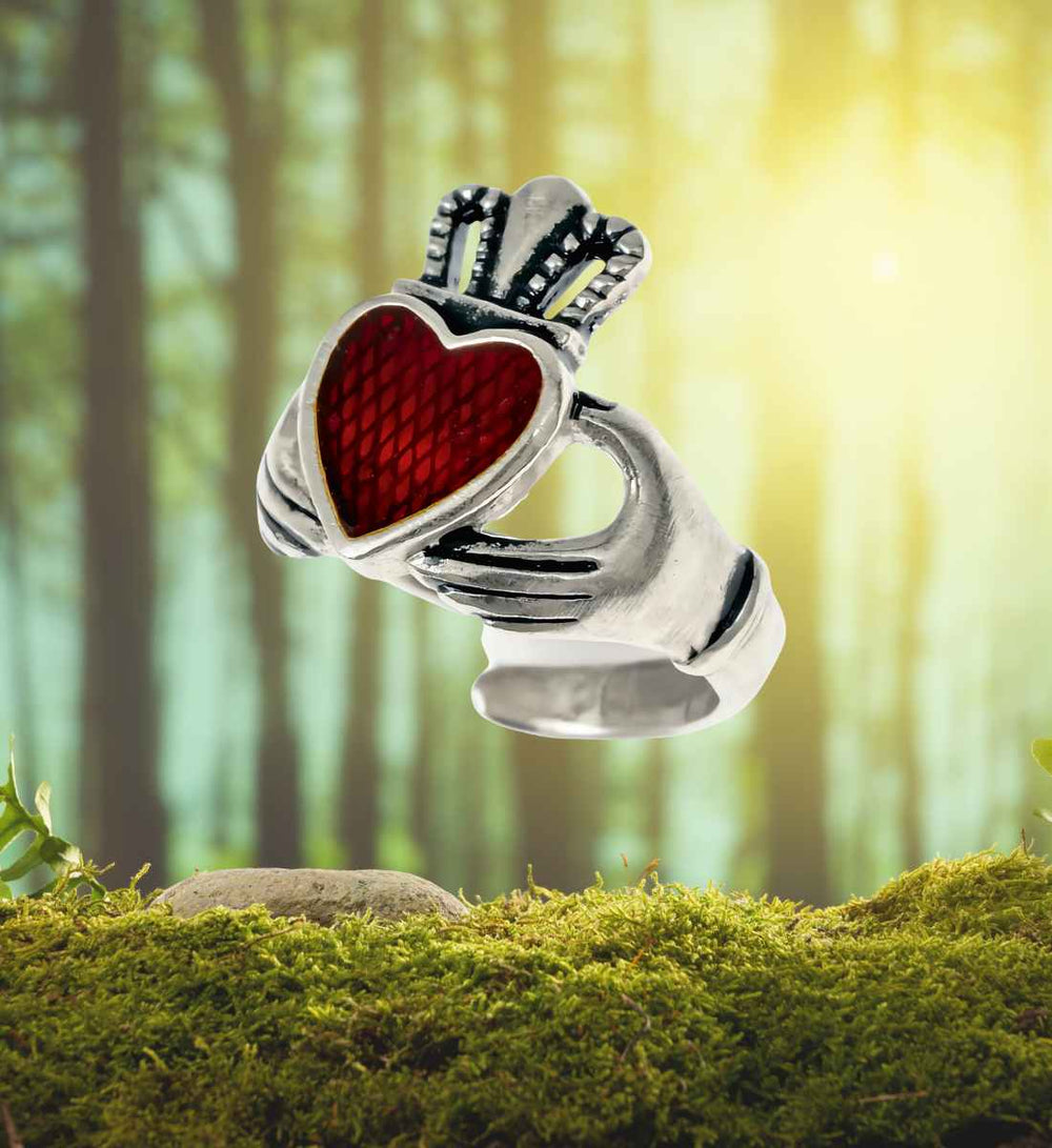 Claddagh Ring der Treue – Liebes- und Freundschaftsring aus echt versilberter Bronze mit roter Glaseinlage auf Moos/Wald Hintergrund