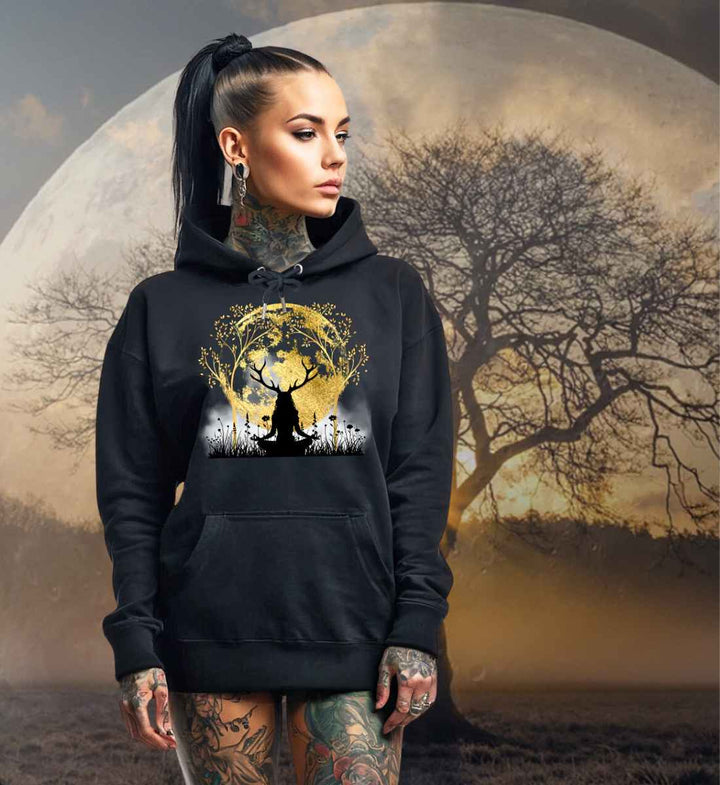 Junge Frau im 'Druidin der alten Wälder' Organic Unisex Hoodie in Schwarz, vor einem mystischen Mond und einem Lebensbaum, der die tiefe Verbindung zwischen Mensch und Natur symbolisiert.