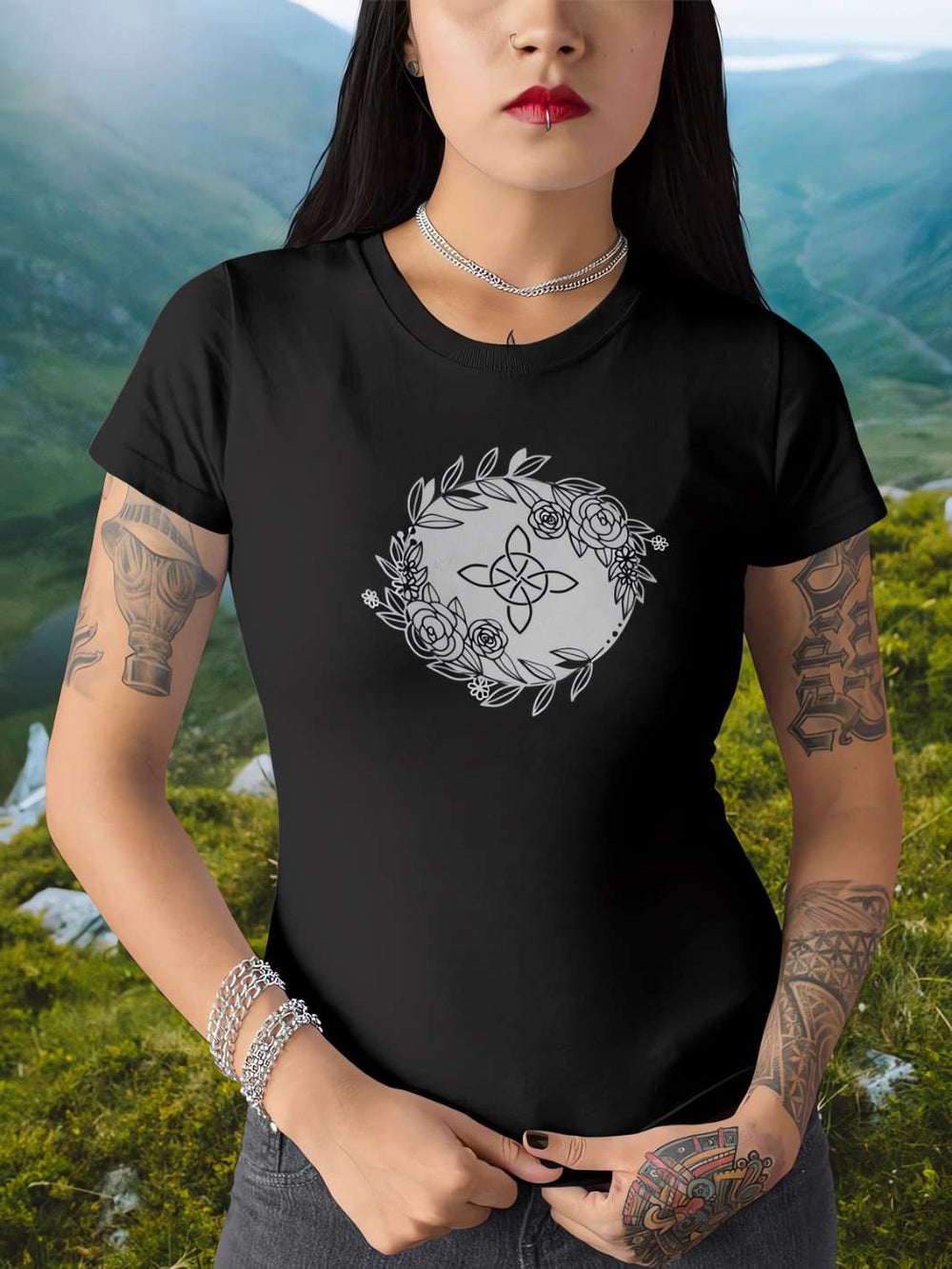 unge Frau trägt ein 'Eriu Witch Knot'-T-Shirt in schwarz, posierend in einer keltischen Landschaftsumgebung, die Ruhe und Mystik ausstrahlt."