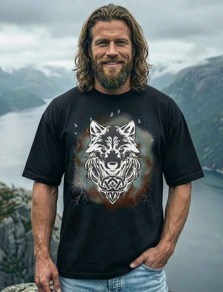 Model trägt schwarzes Fenrir Oversize Shirt mit großem Wolfsmotiv aus der nordischen Mythologie, an einem norwegischen Fjord.