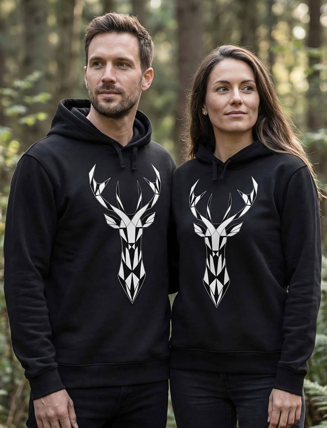 Unisex Hoodie schwarz mit geometrischem Hirschkopf Design, getragen von Mann und Frau im Wald, Bio Baumwolle