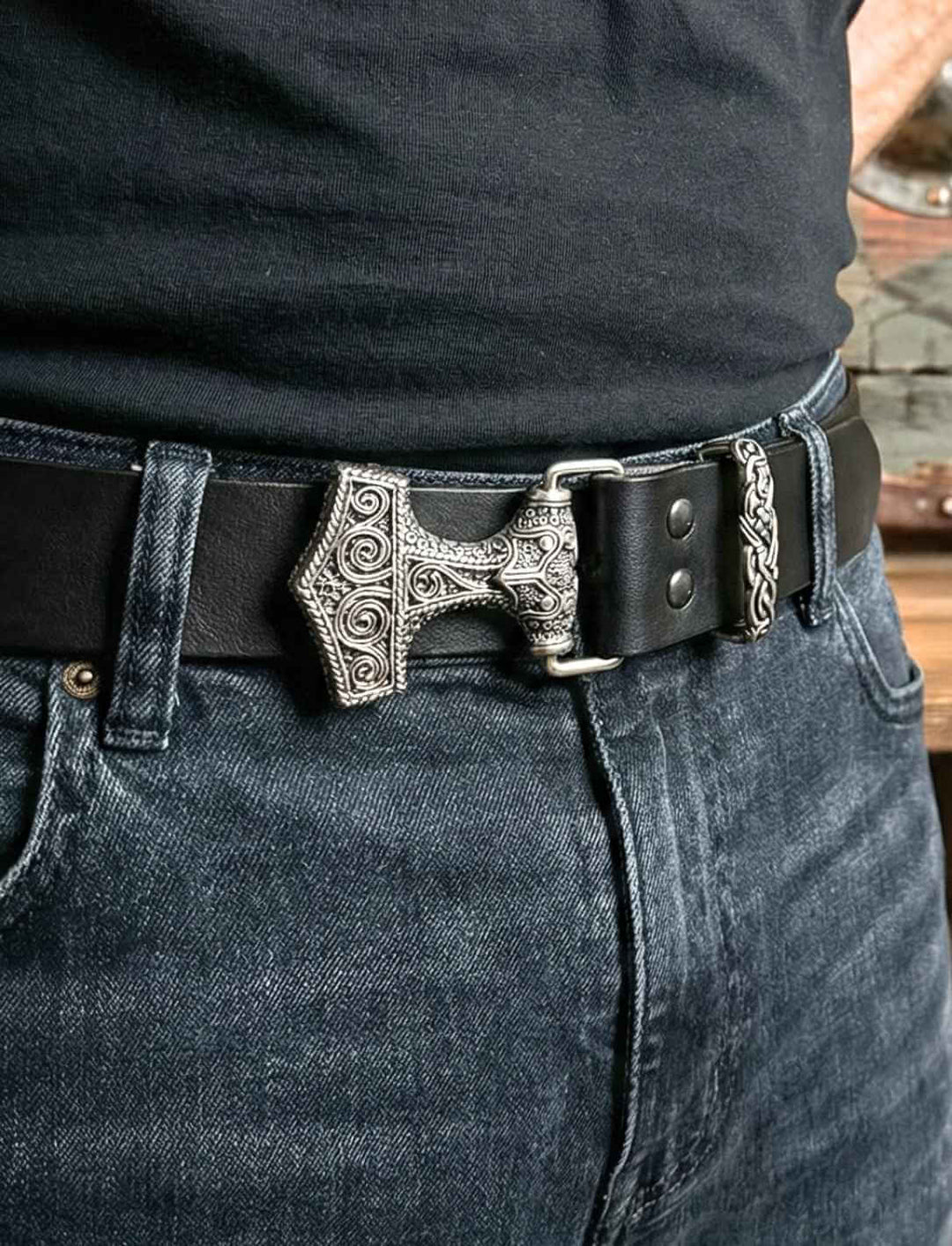 Schwarzer Ledergürtel mit Thorshammer-Schnalle im Wikingerstil, getragen an Jeans