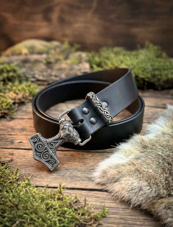 Nordischer Ledergürtel mit Thorshammer-Schnalle, liegend auf Holzuntergrund mit Fell und Naturmaterialien