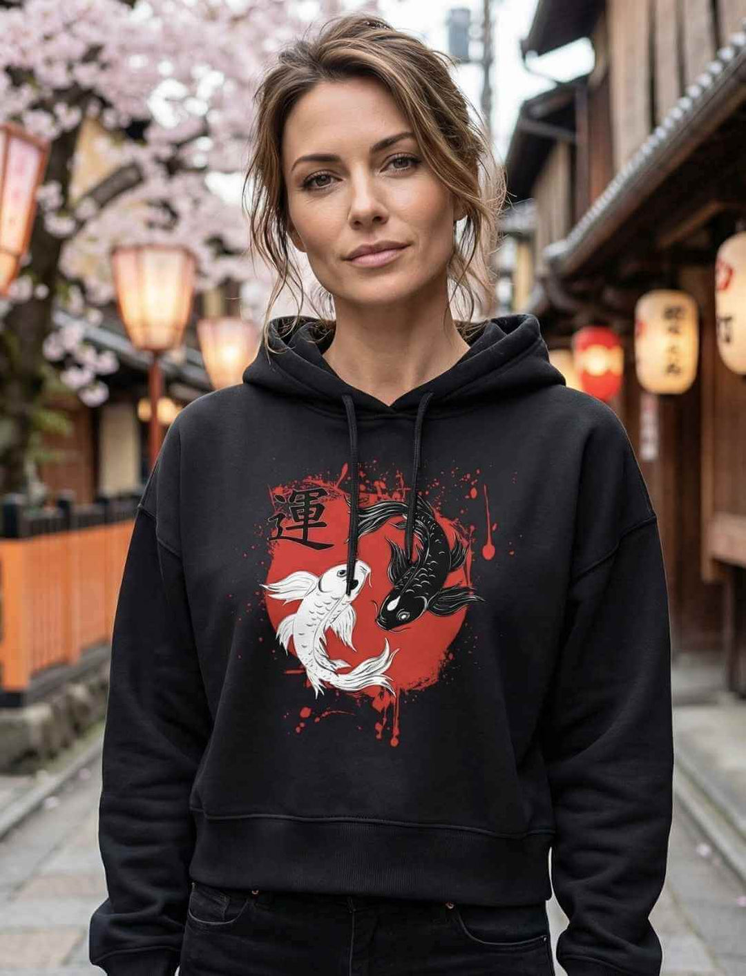 Model trägt schwarzen Boxcut Hoodie mit Harmonic-Koi-Motiv in japanischer Gasse