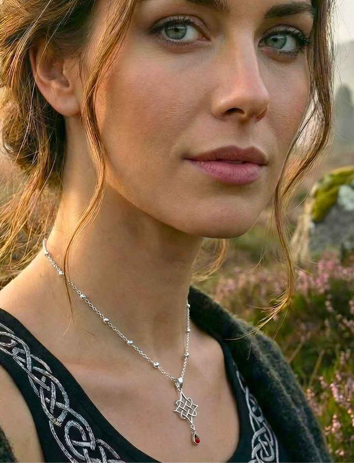 Model trägt Silberanhänger "Herz des alten Hains" mit rotem Schmuckstein an Silberkette "Schimmernde Himmelsperlen"