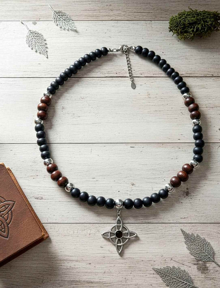 Holzperlenkette mit silberfarbenem vierarmigem Knotenanhänger und Onyx Schmuckstein.