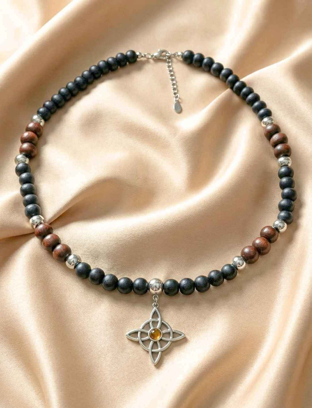 Holzperlenkette mit silberfarbenem vierarmigem Knotenanhänger und Onyxperlen