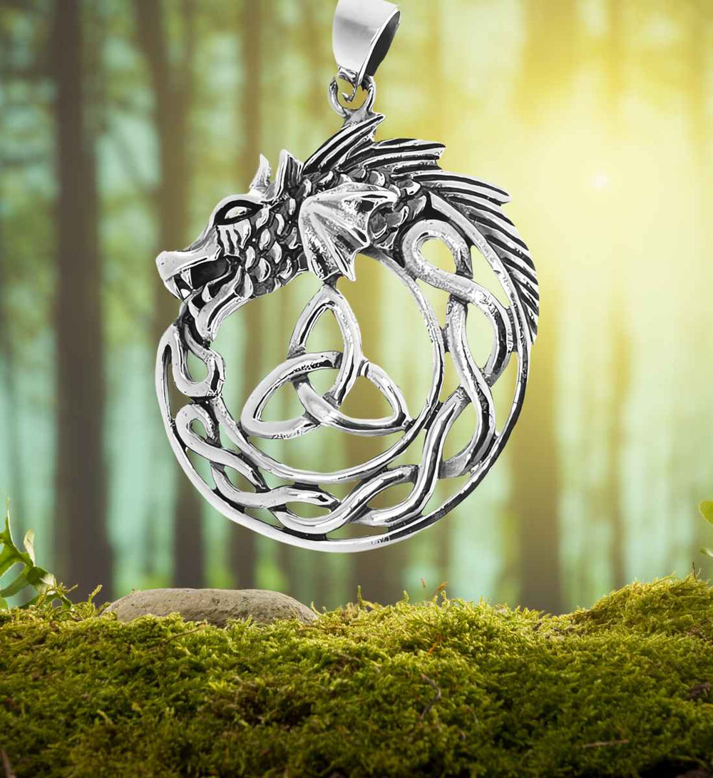 Keltischer Drache der Sidhe Anhänger auf einem Moos-/Waldhintergrund – Der Anhänger verschmilzt mit der natürlichen Szenerie, seine keltischen Knoten und der majestätische Drachenkopf rufen die Geisterwelt der Sidhe hervor.