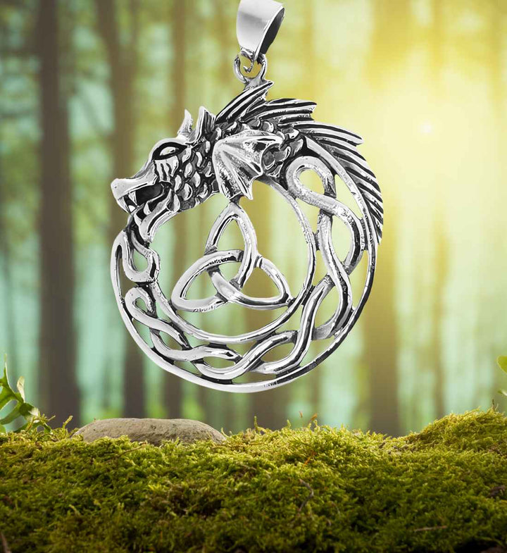 Keltischer Drache der Sidhe Anhänger auf einem Moos-/Waldhintergrund – Der Anhänger verschmilzt mit der natürlichen Szenerie, seine keltischen Knoten und der majestätische Drachenkopf rufen die Geisterwelt der Sidhe hervor.