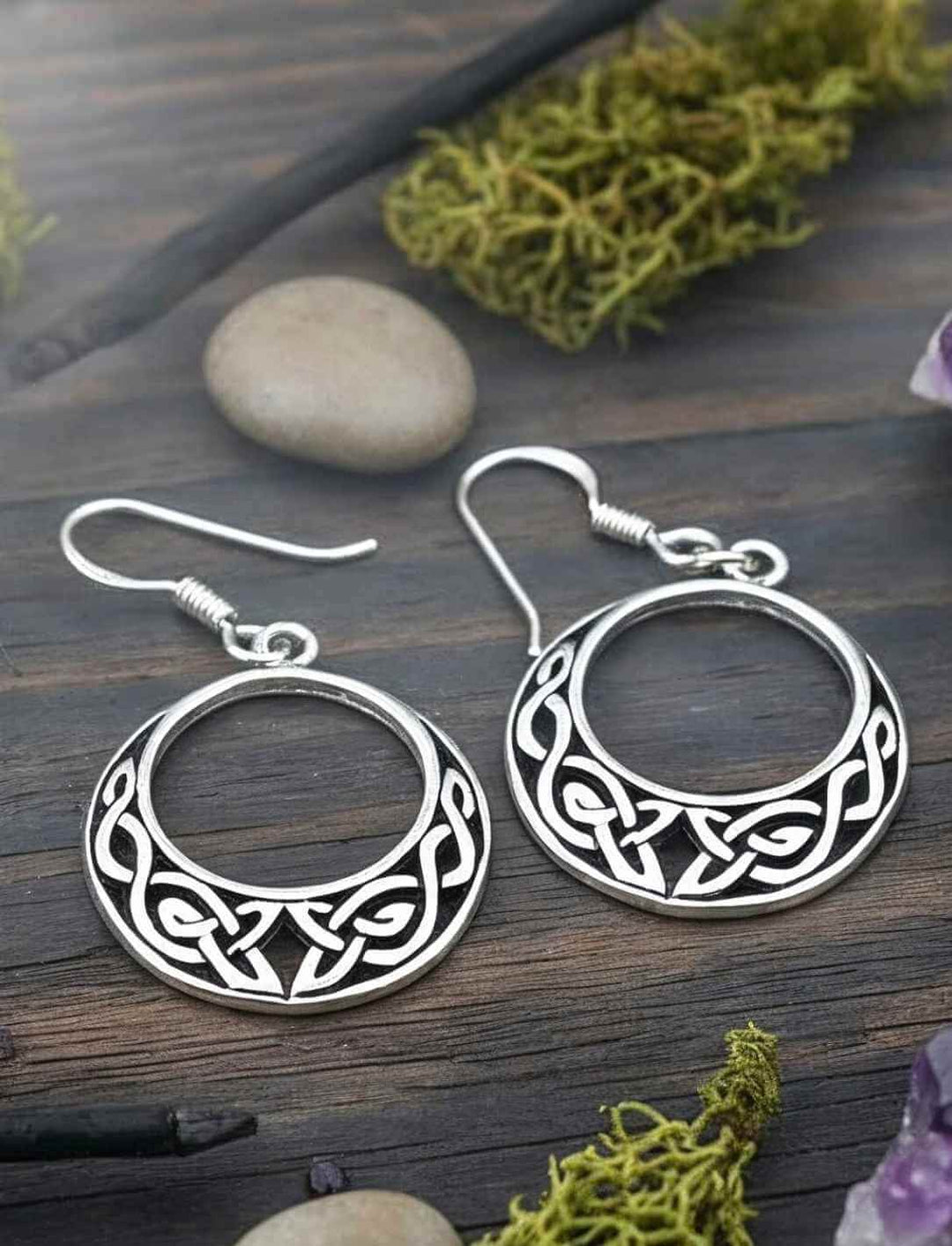 Keltische Silberohrringe mit rundem Knotenmotiv auf Holz, Moos und Steinen