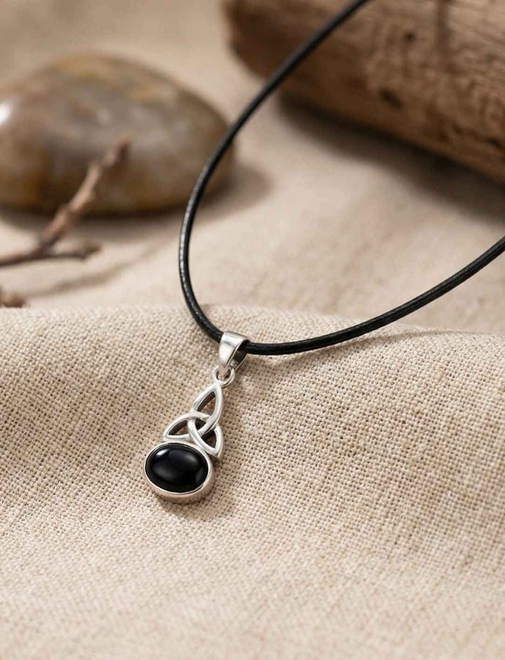 Knoten von Ériu Anhänger aus Silber mit schwarzem Onyx an Band getragen