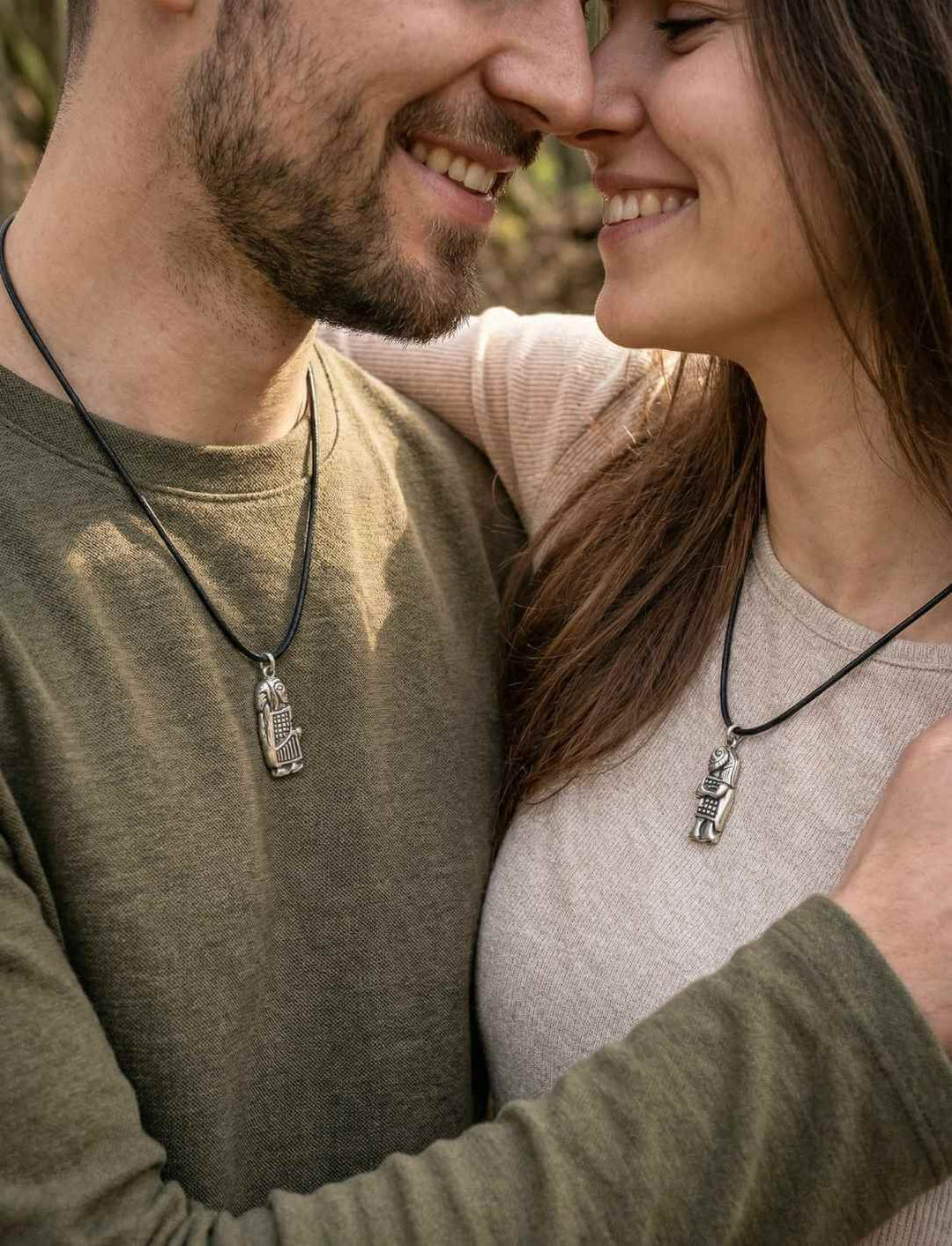 Mann und Frau tragen je ein Anhänger Kuss des Wikingers, versilberte Bronze.