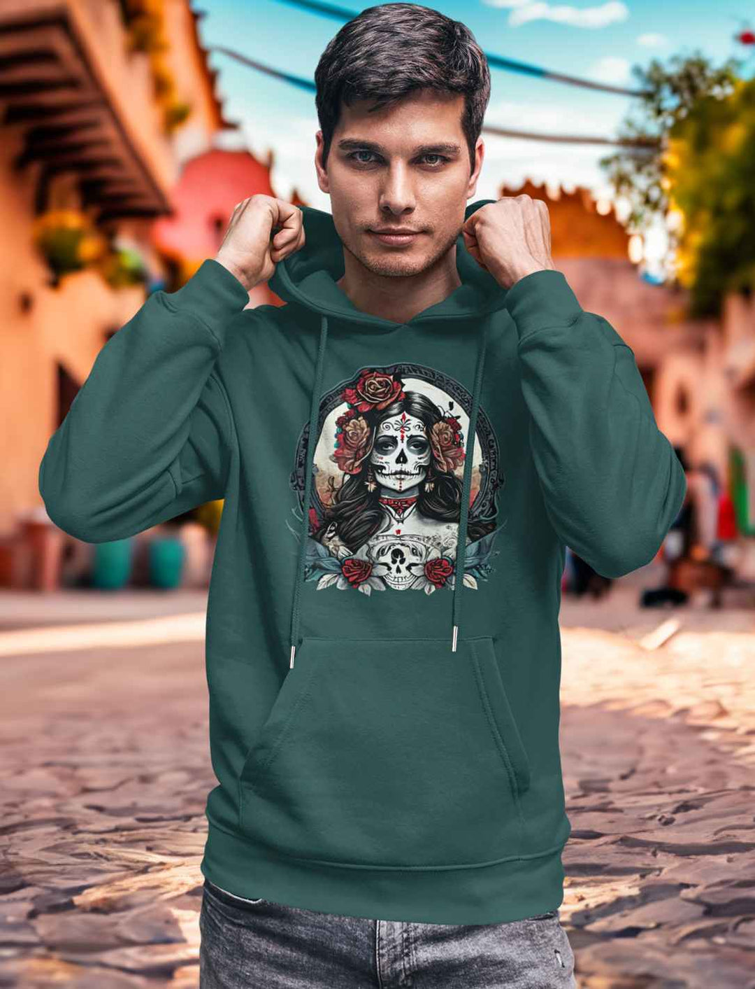 Junger Mann im Glazed Green La Catrina Organic Hoodie, stehend auf einer malerischen mexikanischen Straße während des Dia de los Muertos – Runental.de