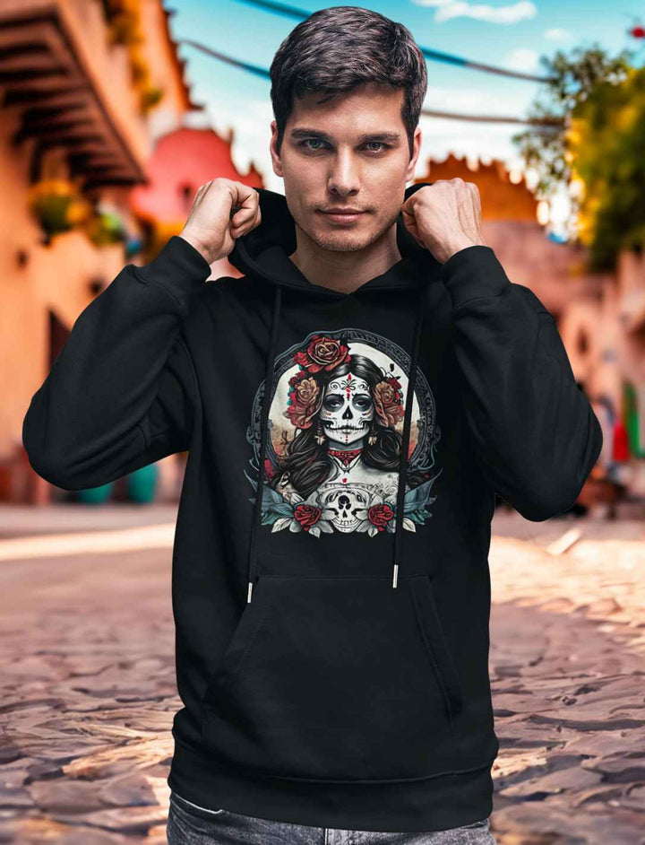 Junger Mann in schwarzem La Catrina Organic Hoodie, stehend auf einer typischen mexikanischen Straße während des Dia de los Muertos – Runental.de