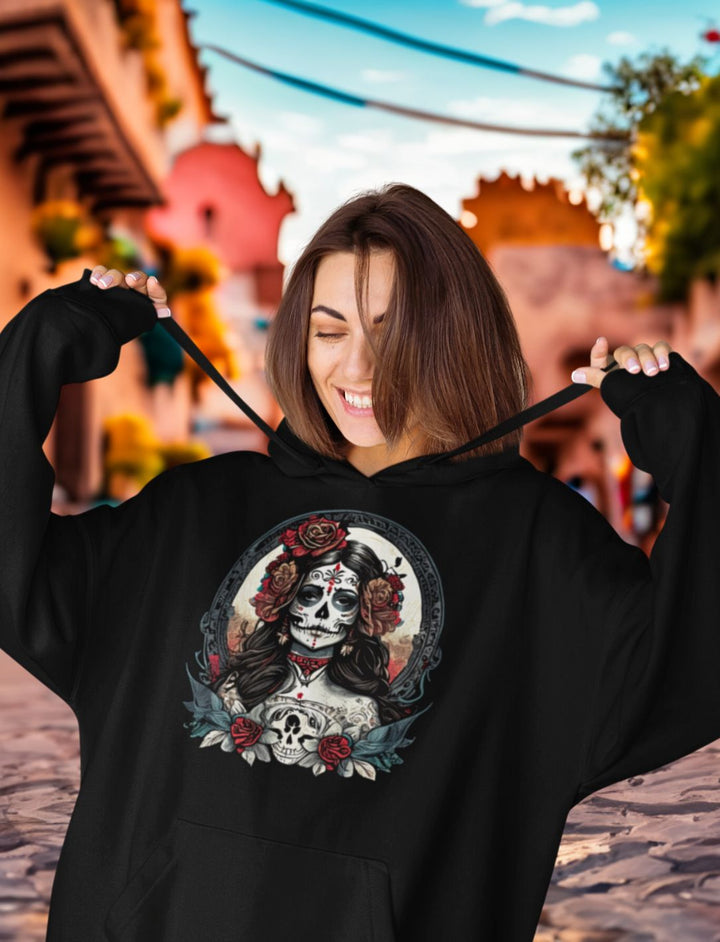 Junge Frau trägt schwarzen Oversized La Catrina Hoodie, stehend auf einer typischen mexikanischen Straße während des Dia de los Muertos – Runental.de