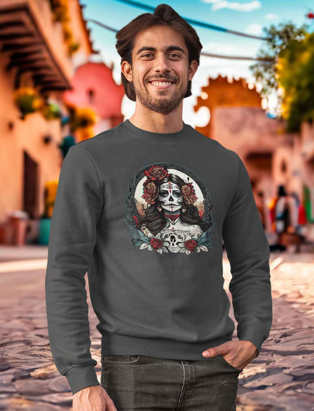 Junger Mann im India Ink Grey La Catrina Organic Sweatshirt, stehend auf einer charakteristischen mexikanischen Straße am Dia de los Muertos – Runental.de
