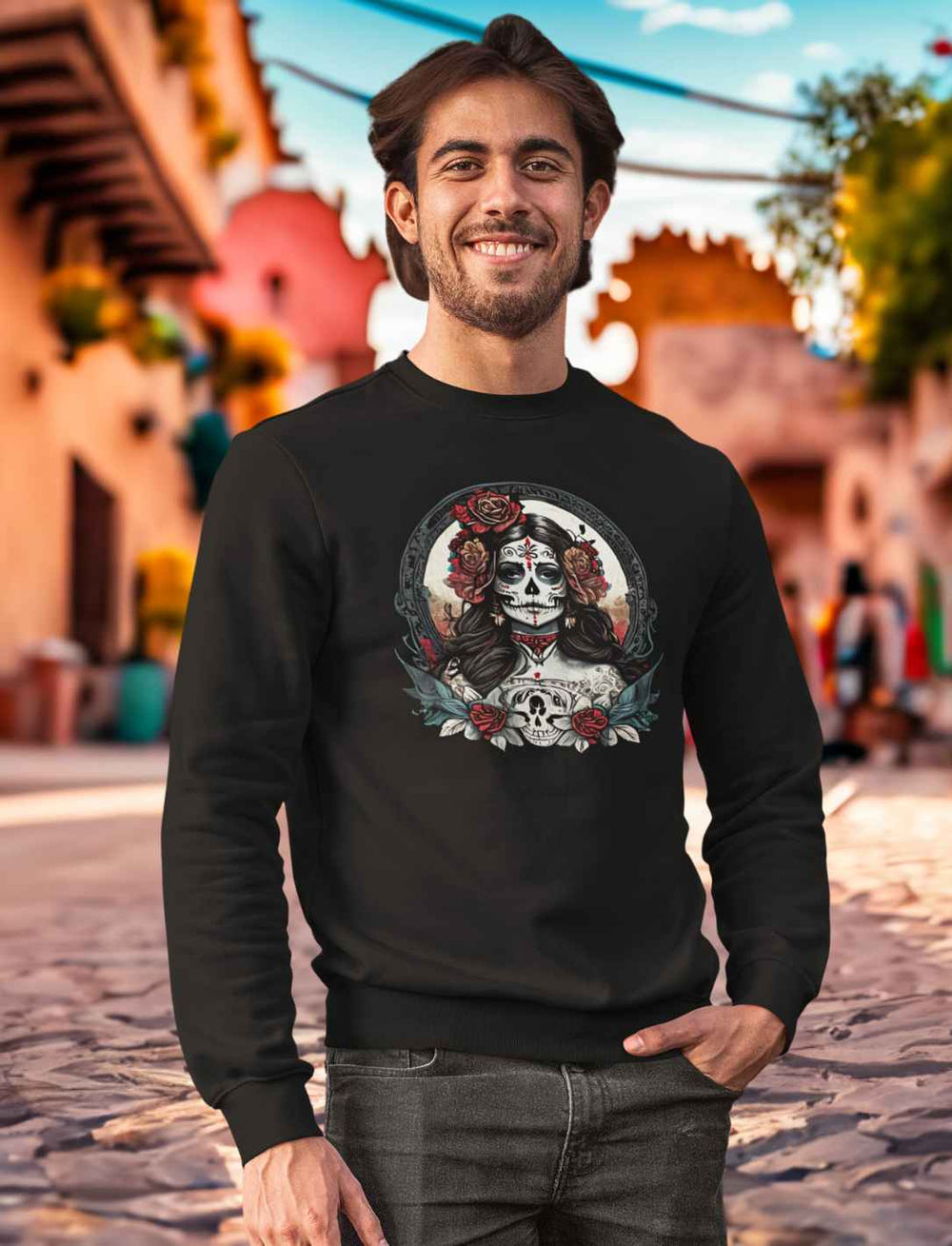 Junger Mann in schwarzem La Catrina Organic Sweatshirt, stehend auf einer typischen mexikanischen Straße während des Dia de los Muertos – Runental.de