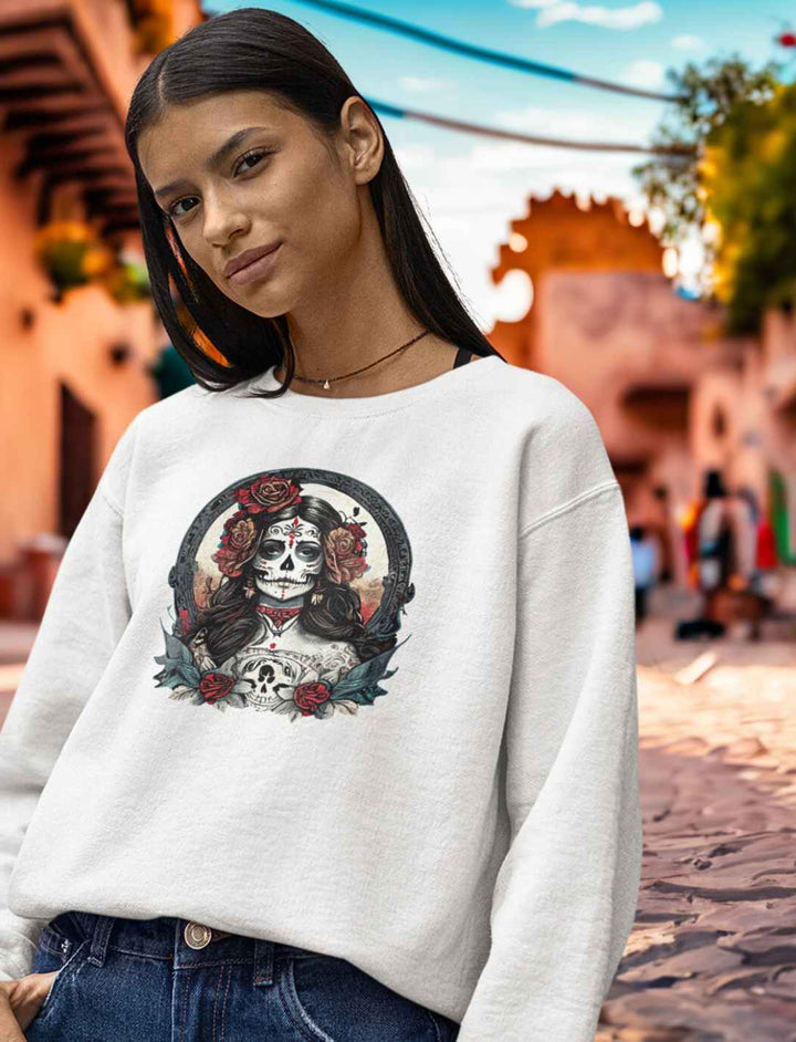 Junge Frau im weißen La Catrina Organic Sweatshirt, stehend auf einer traditionellen mexikanischen Straße zum Dia de los Muertos – Runental.de