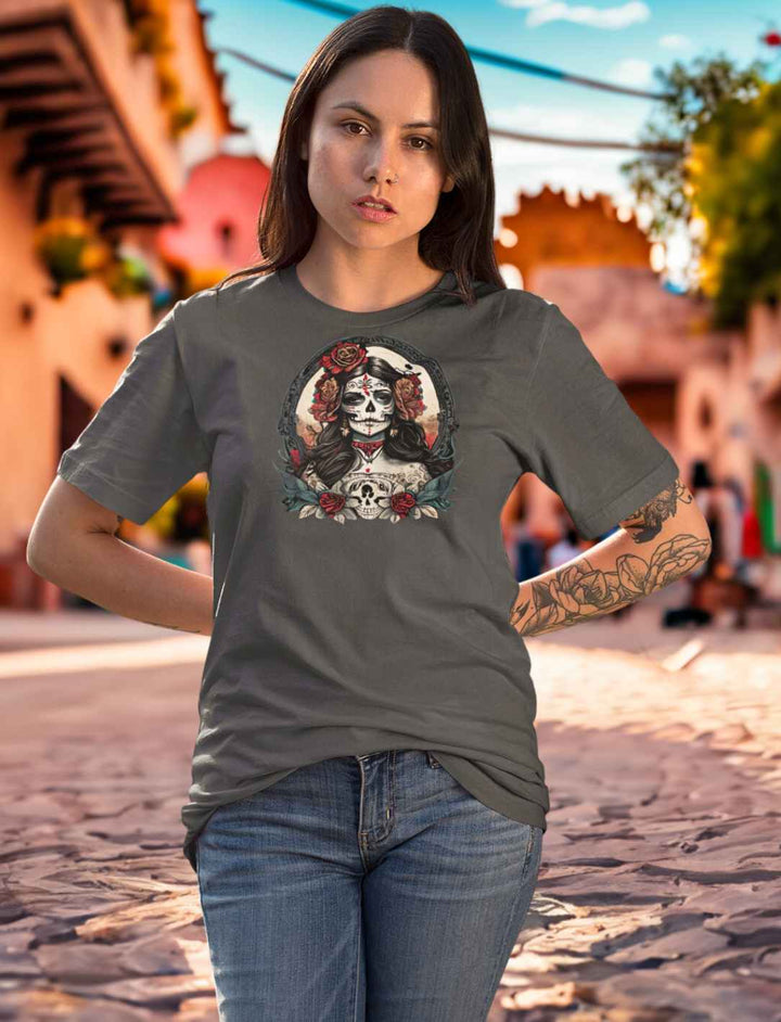 Junge Frau im India Ink Grey Unisex La Catrina Shirt, stehend auf einer historischen mexikanischen Straße während des Dia de los Muertos – Runental.de