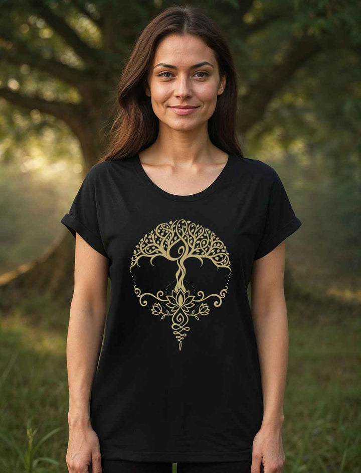 Frau im Wald mit schwarzem Damen Longfit Shirt und goldenem Lebensbaum-Lotus-Motiv, meditierend in der Morgensonne