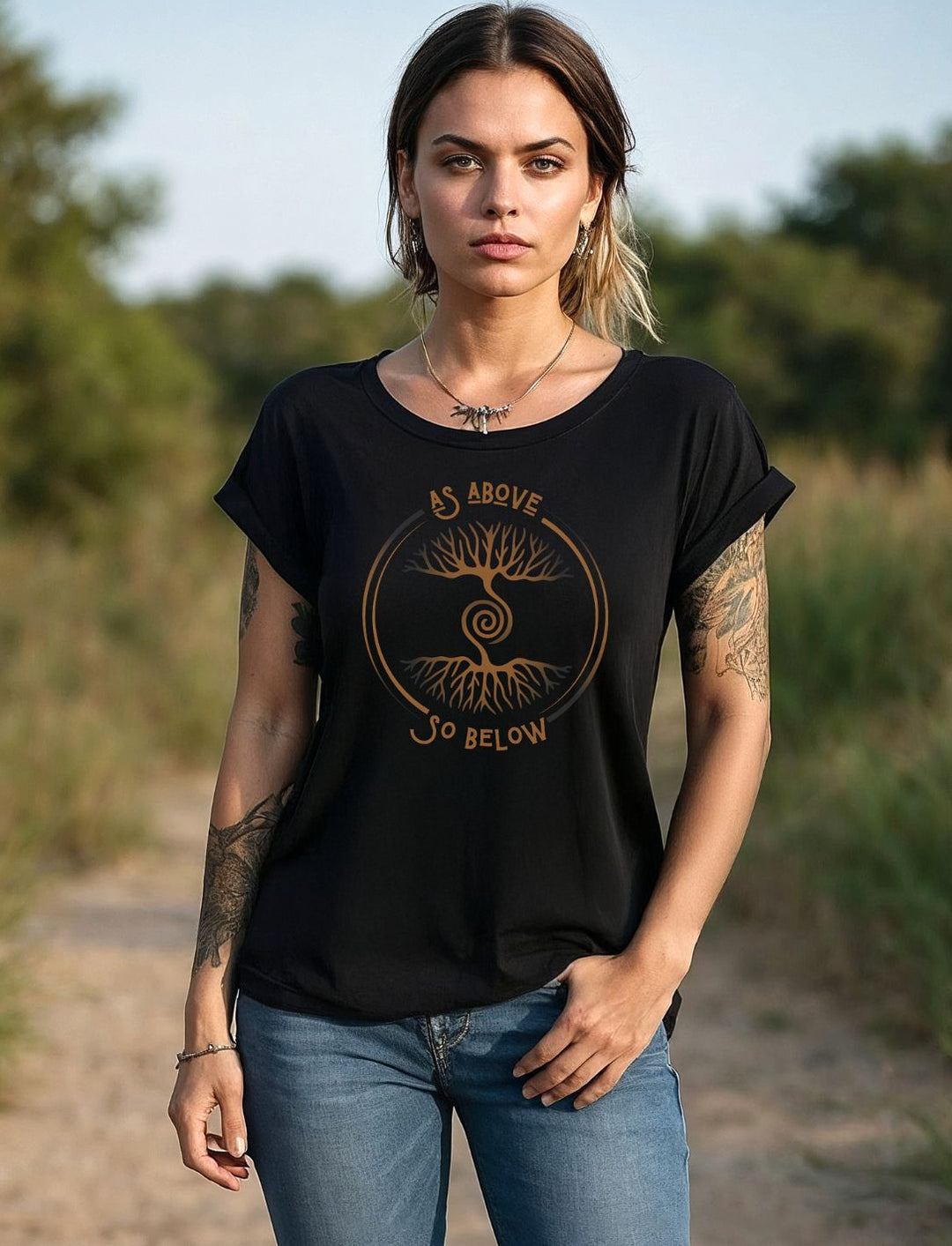  Frau trägt schwarzes Damen Shirt „Lebenswurzel der Verbundenheit“ mit Weltenbaum-Motiv im Freien