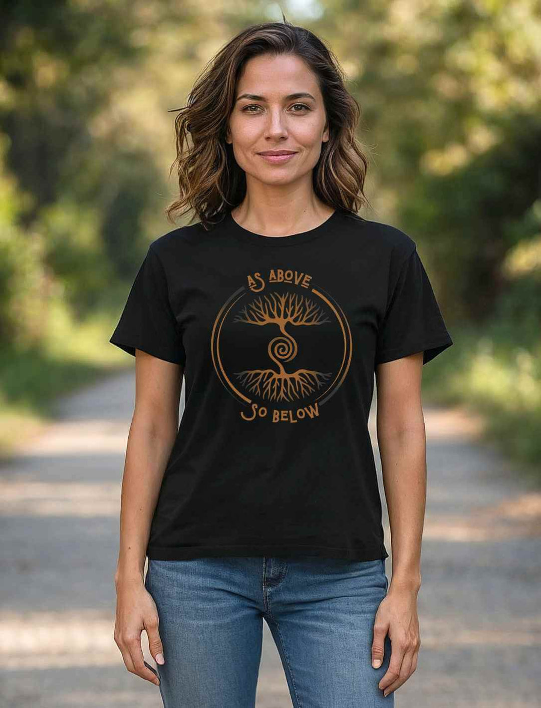 Frau trägt schwarzes Damen Organic Shirt „Lebenswurzel der Verbundenheit“ mit Weltenbaum-Symbol im Freien
