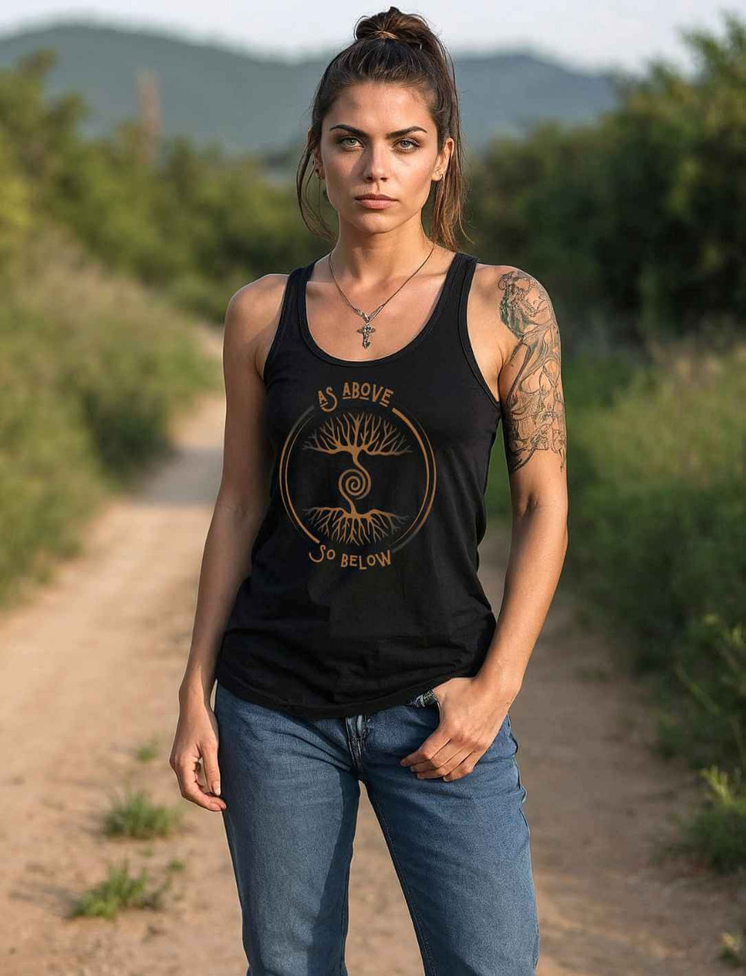 Frau trägt schwarzes Damen Tank Top „Lebenswurzel der Verbundenheit“ mit Weltenbaum-Design auf Feldweg