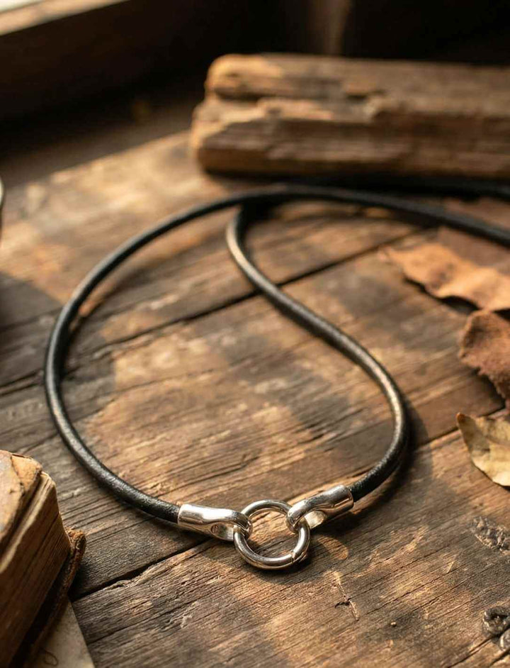 Schwarze Lederkette des alten Bundes aus Echtleder mit Edelstahlclip auf Holzuntergrund