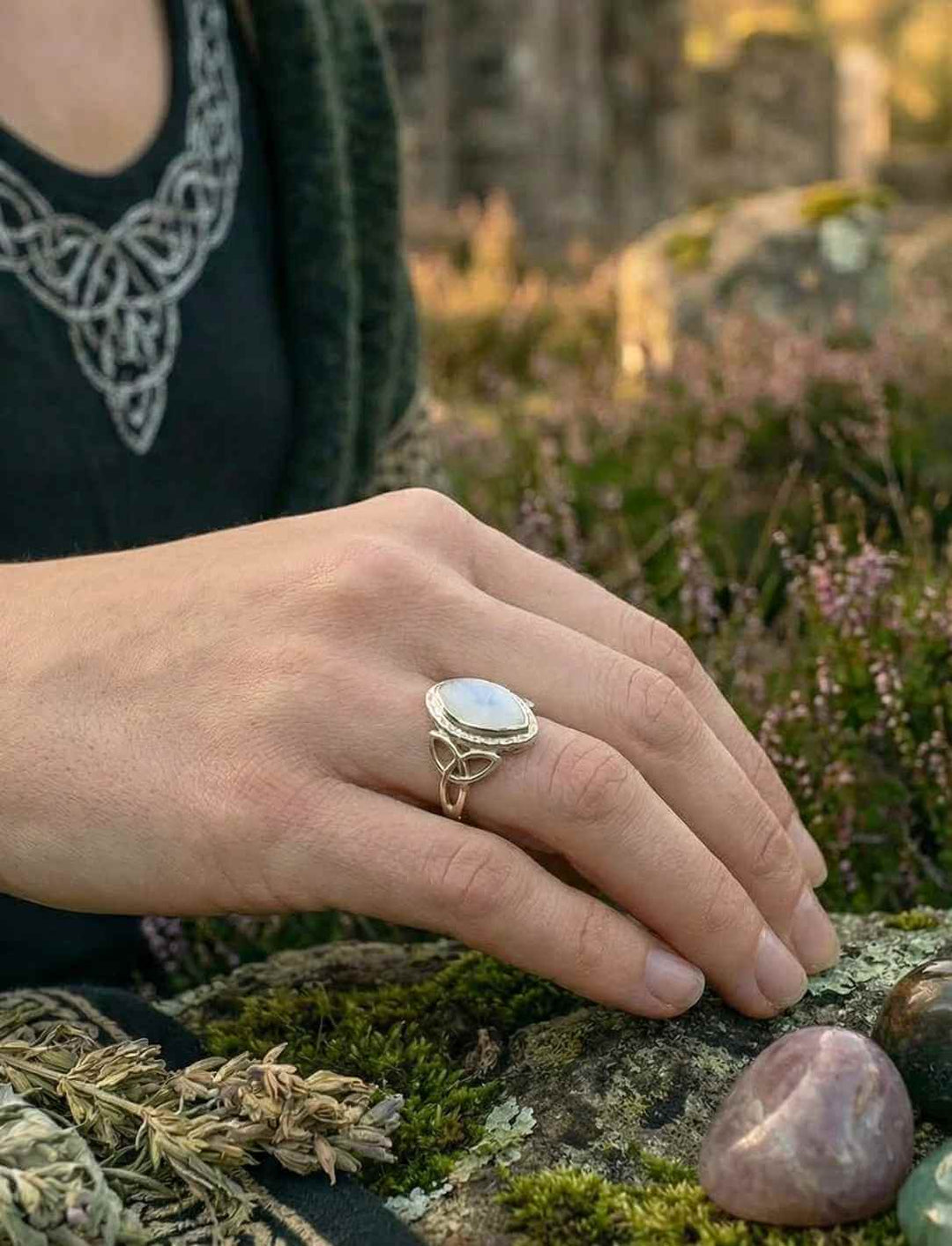 Frau trägt keltischen Mondsteinring aus Silber in natürlicher Umgebung