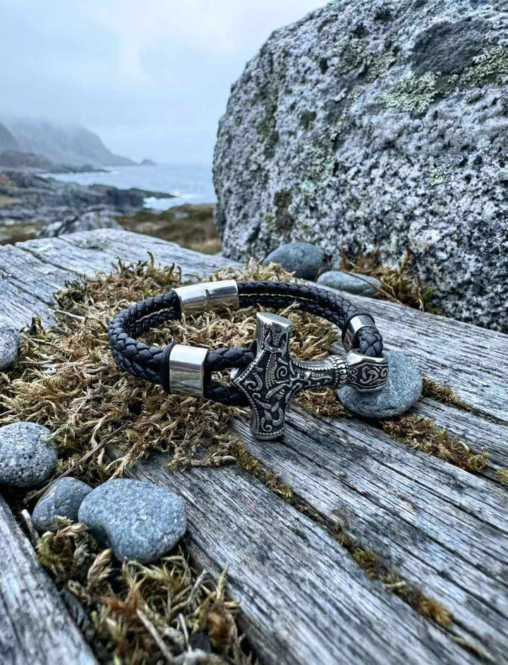Nordisches Lederarmband mit Thors Hammer auf Felsen in rauer Umgebung