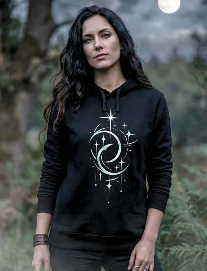 Frau trägt schwarzen Unisex Hoodie mit Doppelmond Balance Design im Wald bei Nacht