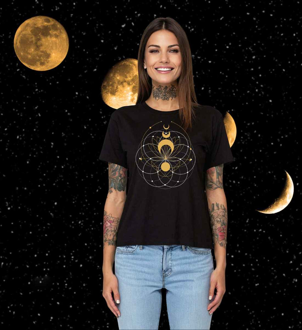 Lächelnde Frau in schwarzem T-Shirt mit 'Mondblüte der Harmonie'-Design, stehend vor Sternen- und Mondhintergrund.