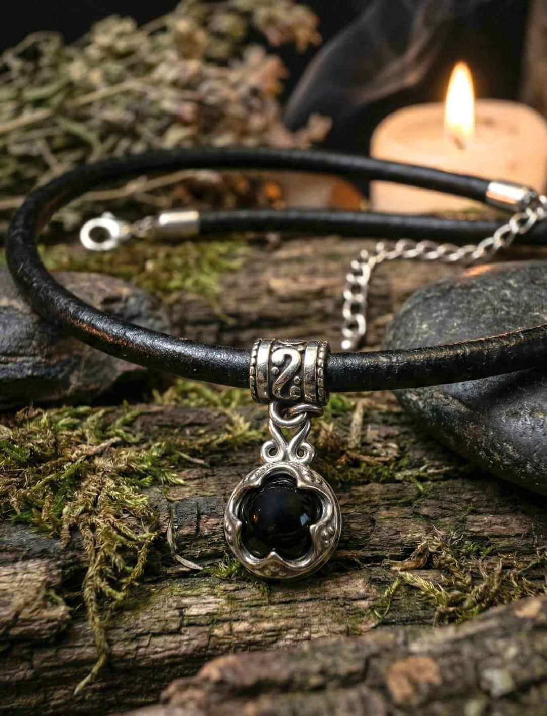 Nahaufnahme von Gotland Onyx Lederkette mit Edelstahl Anhänger und schwarzem Onyx Schmuckstein auf Naturholz und Moos inszeniert