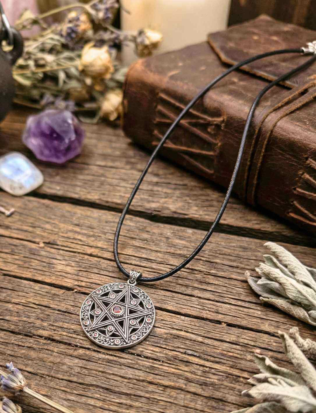 Pentakel Schutzamulett aus Silber mit roten Zirkonia auf rustikalem Holztisch – Wicca Schmuck mit Elementesymbolik