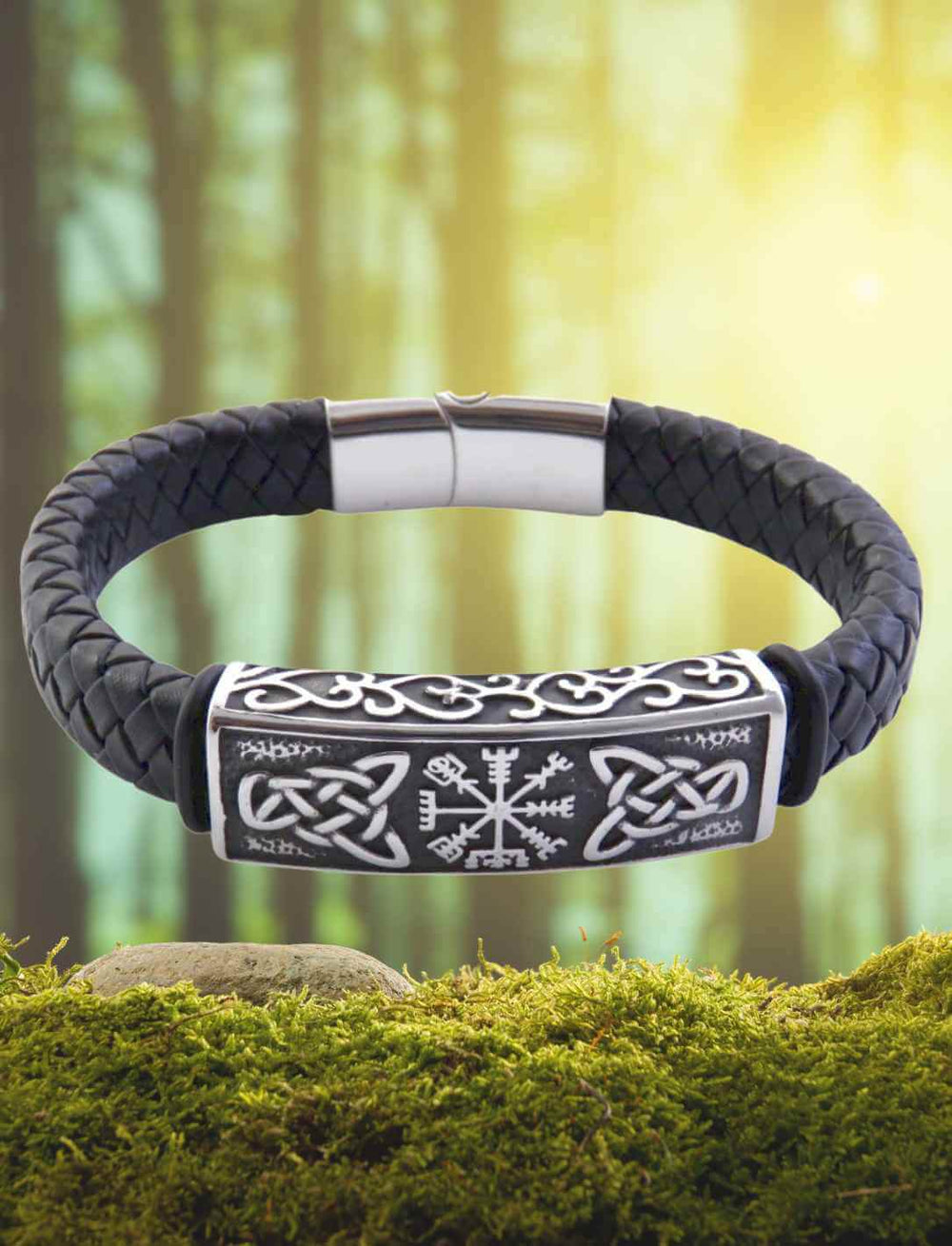 Geflochtenes Lederarmband mit Edelstahl-Elementen, verziert mit Vegvisir und keltischen Knoten, inszeniert in einer Waldkulisse.