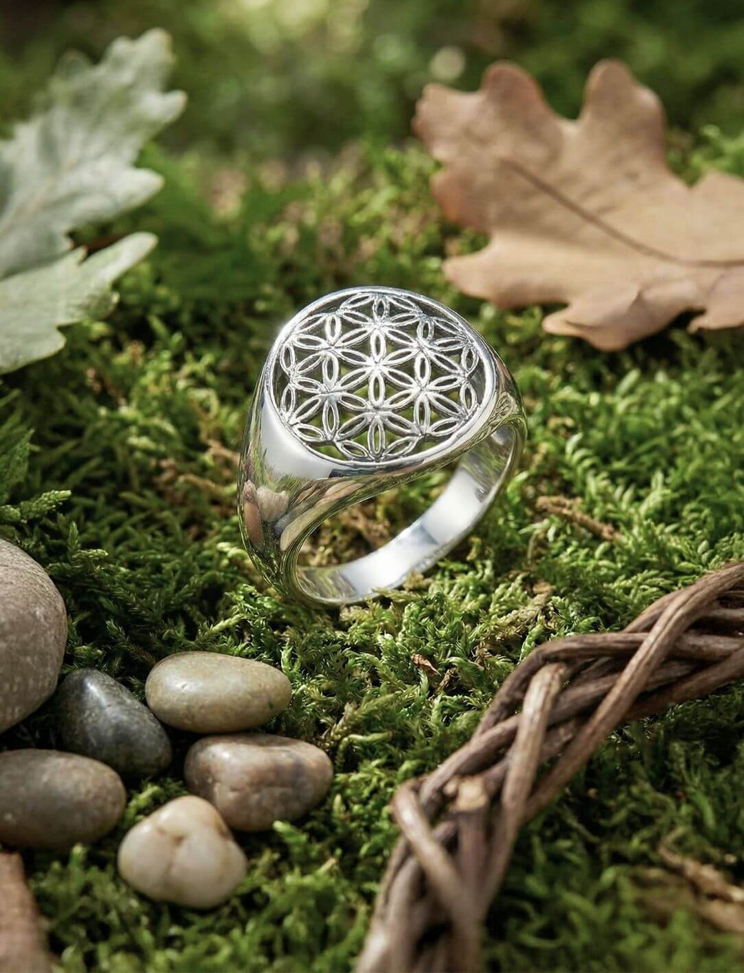 Ring der Blume des Lebens aus 925 Sterling Silber, liegend auf moosigem Waldboden im Natursetting