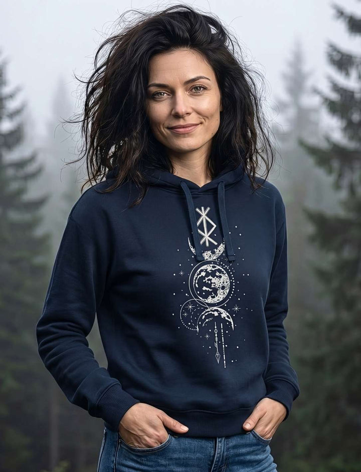 Frau trägt Runen Hoodie in French Navy mit Mondphasen-Design vor nebligem Wald